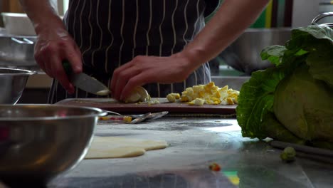 close up of a chef chopping hard boiled eggs, steam rising from the hot eggs