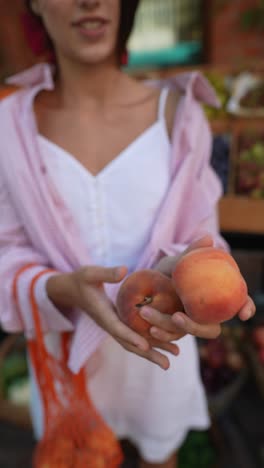 woman buying peaches at a farmers market