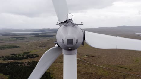 static drone shot of the nacelle, blades and rotor hub on a wind turbine