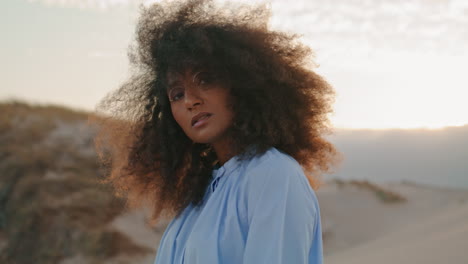 retrato de una mujer afroamericana con el cabello rizado exuberante en un verano sombrío del desierto.