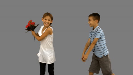 niño ofreciendo un ramo de flores a una niña en la pantalla gris