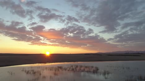 sunrise over a lake in a field