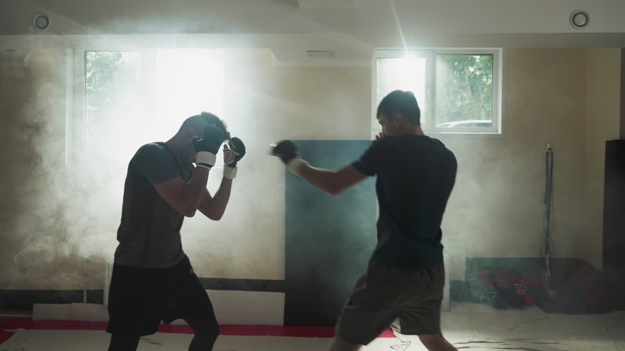 mma 전투기 훈련 스포츠 클럽에서 스파링. 젊은 강한 박서 싸움 빈 안개 체육관에서 운동. 무술 마스터 성과