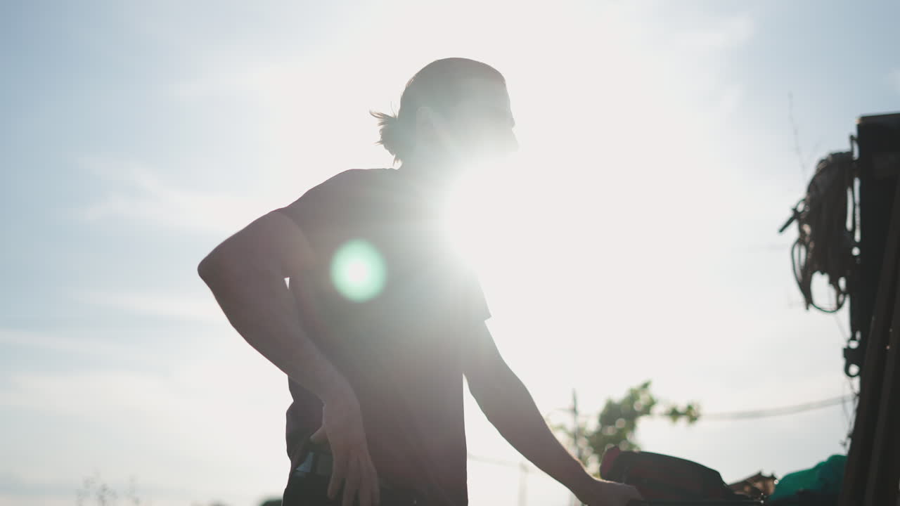 Uomo in piedi in controluce su uno sfondo solare luminoso