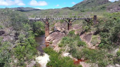 drone view of an old bridge under which river water flows