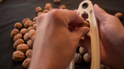 Young man is cracking some fresh dried walnuts-3