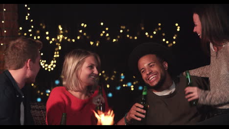 grupo de amigos disfrutando de bebidas nocturnas junto a la chimenea