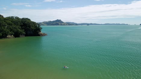 Kayaker-paddling-along-the-coastline-at-white-sand-beach