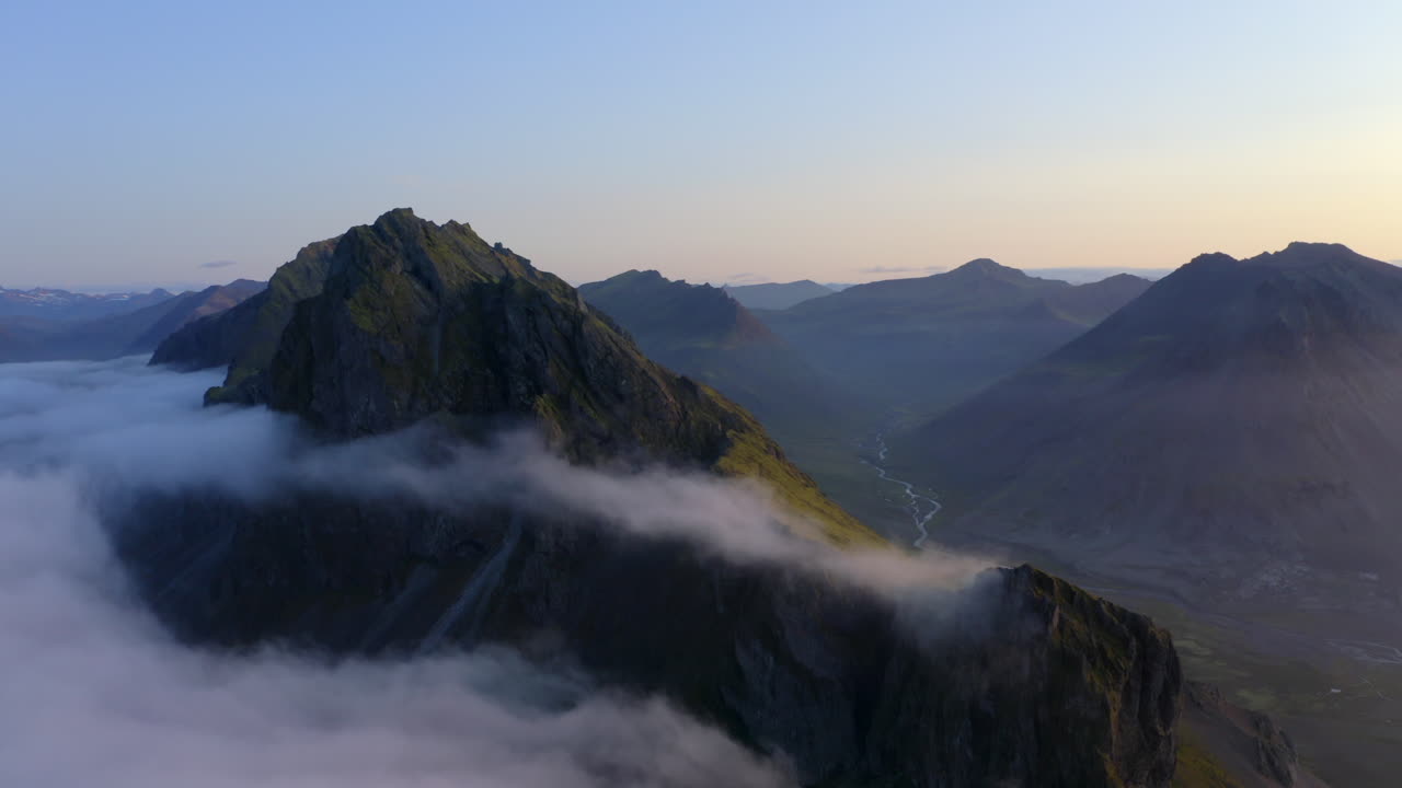 imágenes aéreas de drones de montañas costeras y acantilados cerca de stokkness al amanecer con una hermosa capa de nubes en islandia