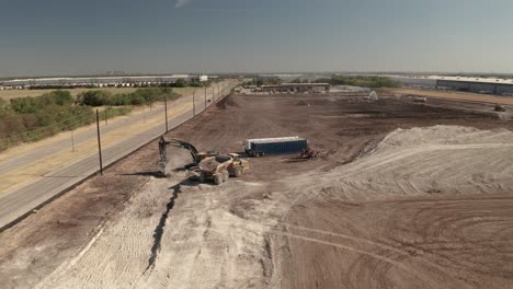 on an excavation site a loader digs dirt to fill up a dump truck