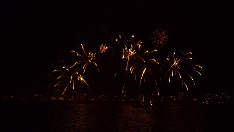 fireworks at sea with cityscape background