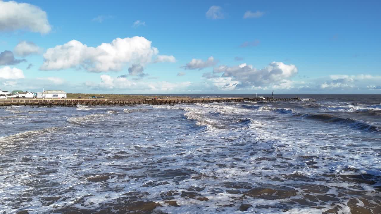 Waves breaking over abandond jetty drone,aerial Southwold Suffolk UK