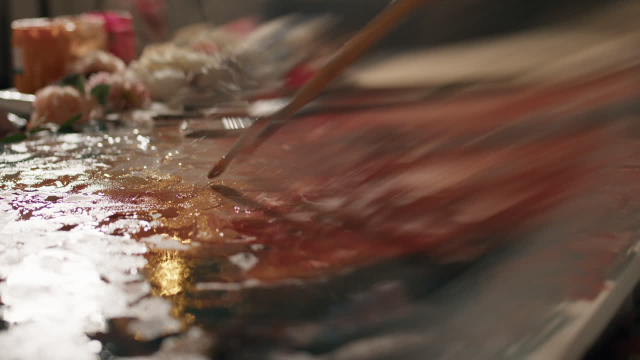 Painter uses brush to create art on canvas in creative studio setting