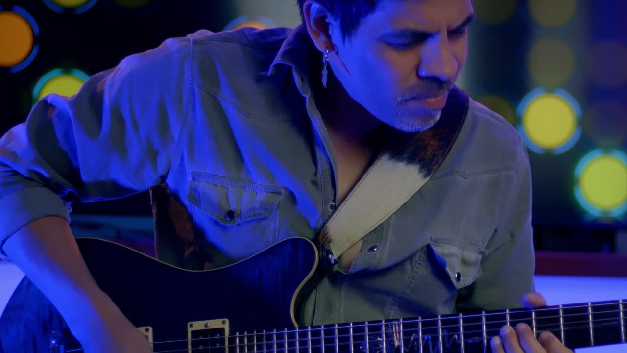 toma en cámara lenta del músico tocando la guitarra, asintiendo con la cabeza con pasión