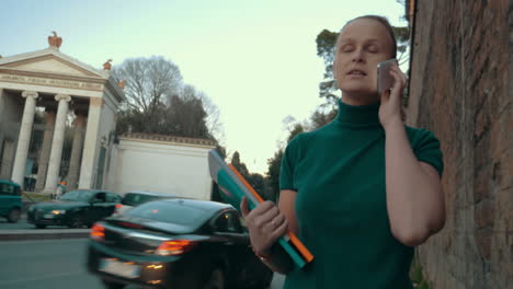 woman with books talking on the phone