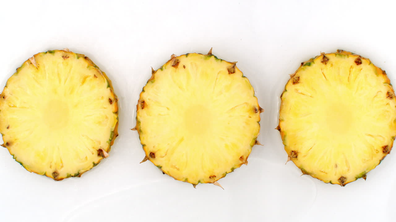 천천히 움직이는 물 어리: 색 배경에 물로 은 달한 파인애플의 세 조각