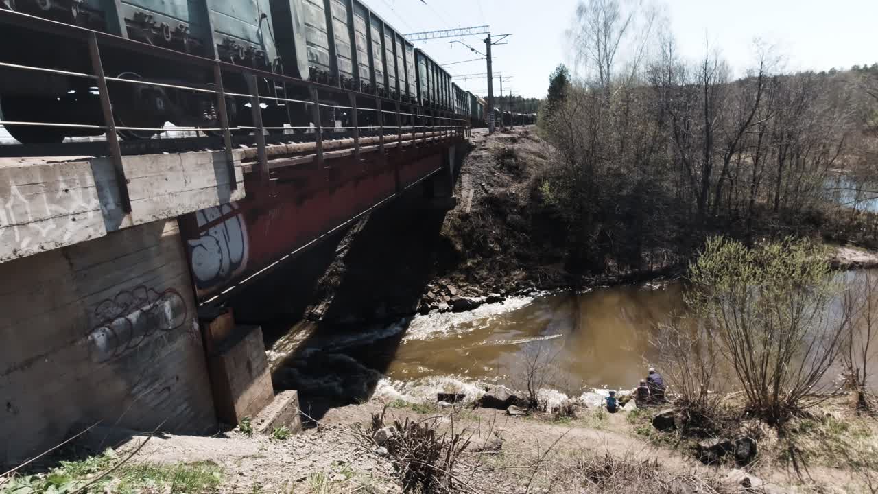 tren de mercancías cruzando un puente sobre un río