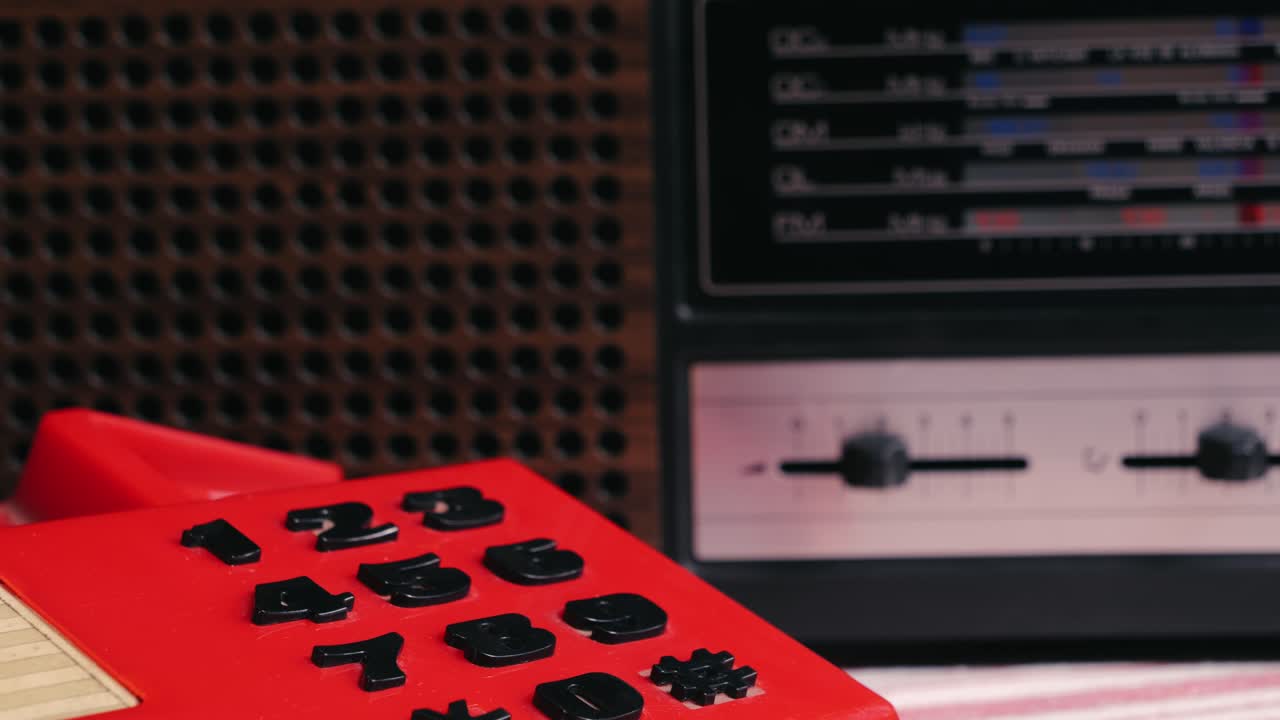 Retro vintage red phone, telephone is displayed on a wooden desk, adding a nostalgic touch. Man answer for call on button 90 phone.