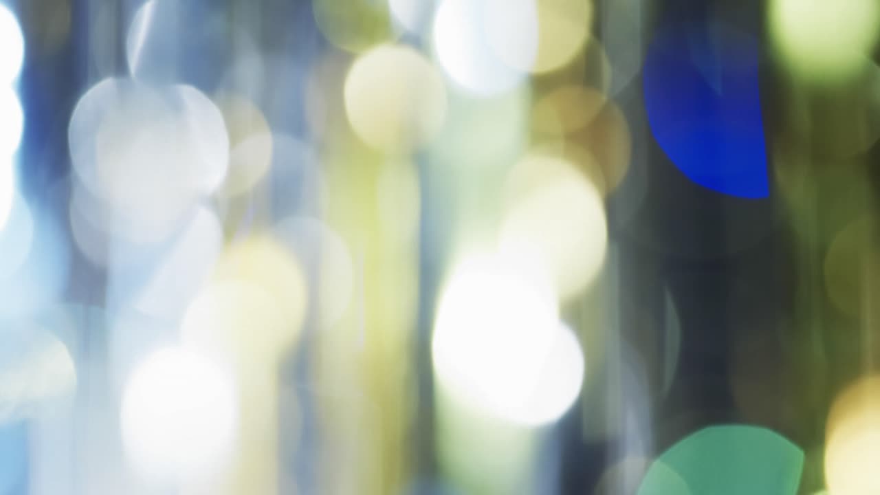 Video of flickering multi coloured bokeh spots of light with copy space