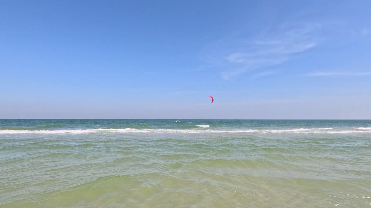 un kitesurfista deslizándose sobre la superficie del mar