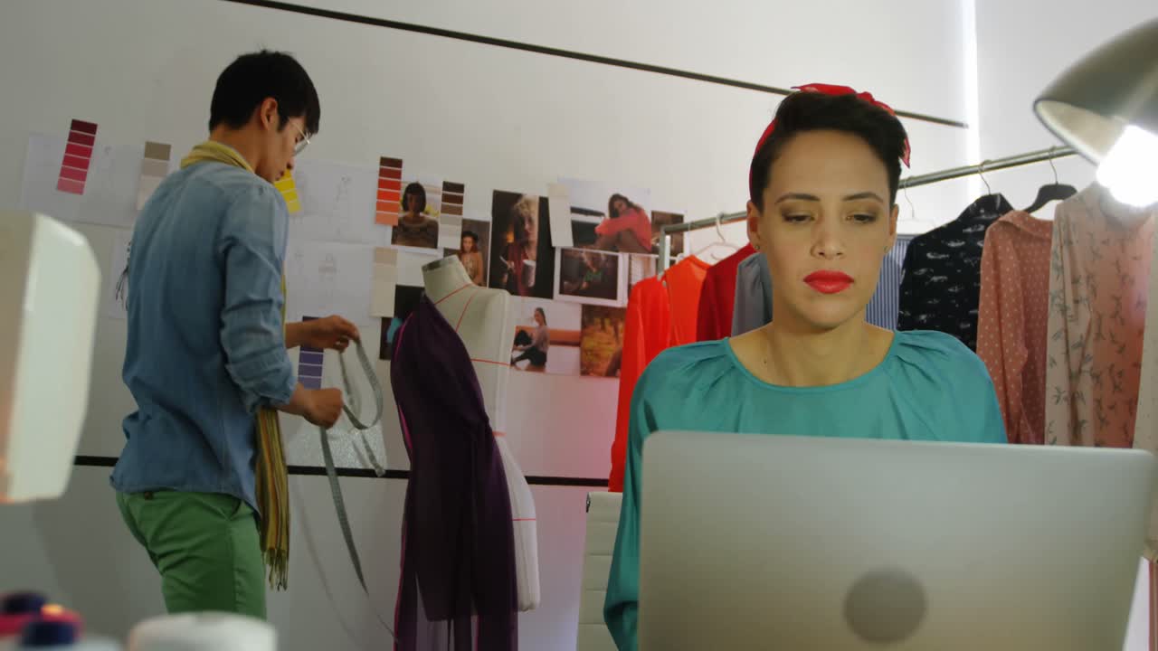 4k 워크 ⁇ 에서 노트북에서 일하는 여성 패션 디자이너의 앞면