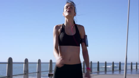 Runner-woman-coming-to-a-stop-on-promenade-after-workout