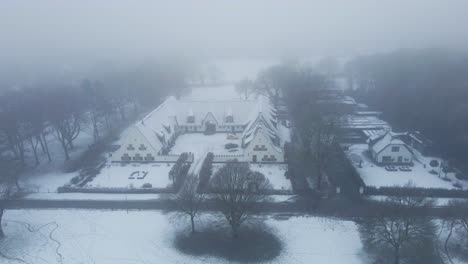 aerial of beautiful old farm building in a rural area in winter