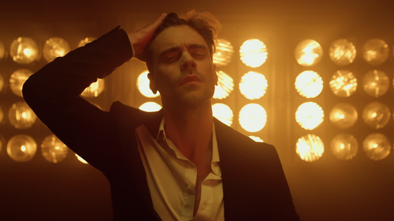 modelo sexy tocando el corte de pelo del club nocturno de cerca. hombre barbudo posando en el estudio.