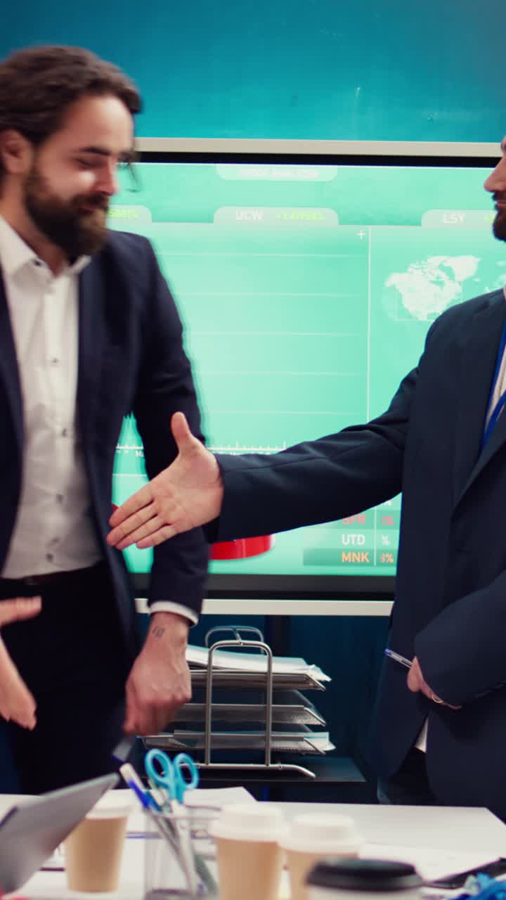 Businessmen Shaking Hands in Office Meeting with Data Display