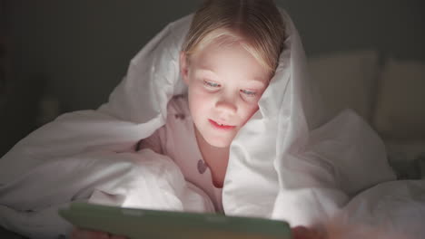 blanket, kid and tablet in bedroom at night