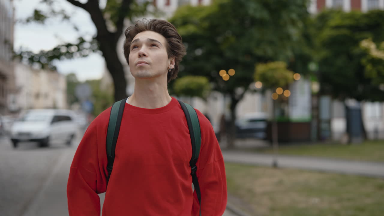 Young Man Walking Down City Street
