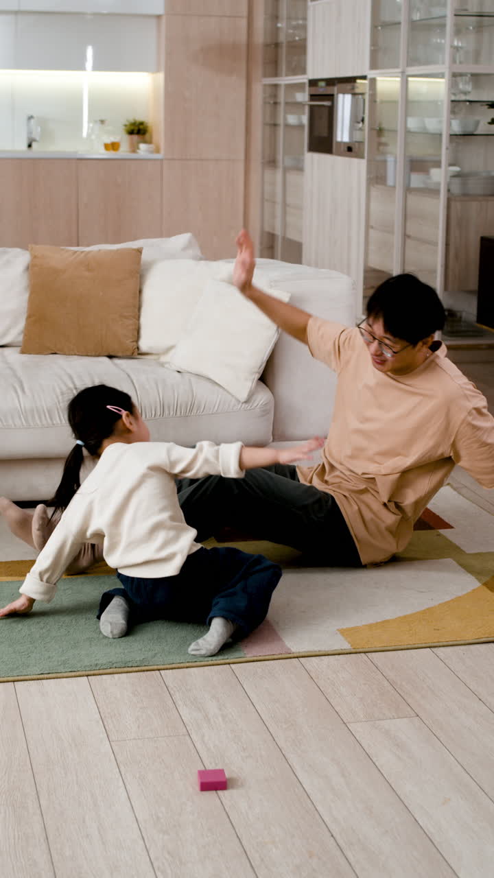 Father and Daughter Playfully Wrestling on the Floor