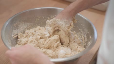 mezclar la masa de levadura para los pierogies con una mano en un cuenco