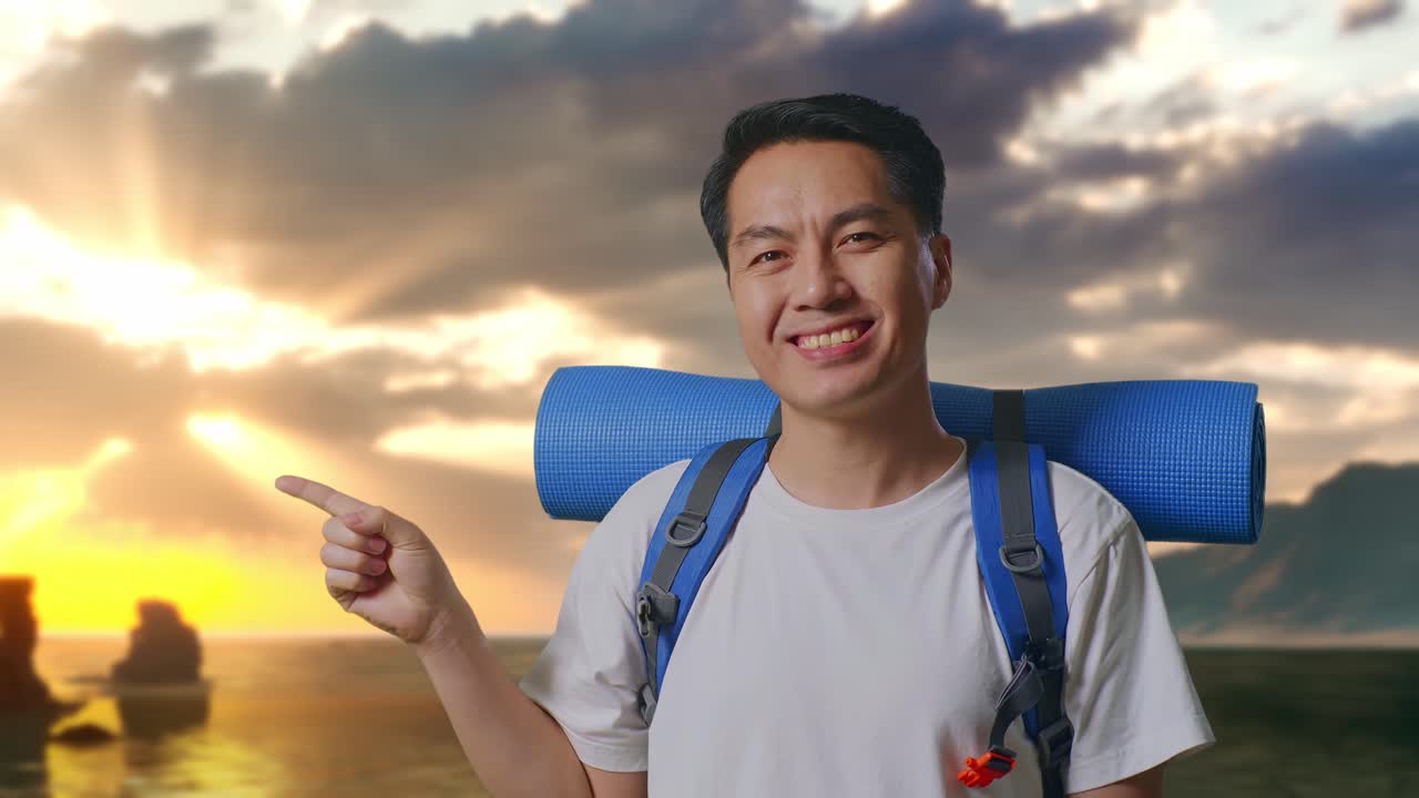 Close Up Pendaki Pria Asia Dengan Ransel Gunung Tersenyum Dan Menunjuk Ke Samping di Pantai