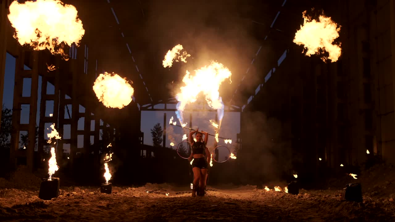 espectáculo de fuego profesional en el antiguo hangar de la aeronave muestran artistas de circo profesionales tres mujeres en trajes de cuero y un hombre con dos lanzallamas.