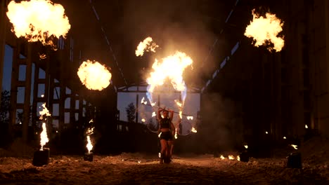 professional fire show in the old hangar of the aircraft show professional circus artists three women in leather suits and a man with two flamethrowers.