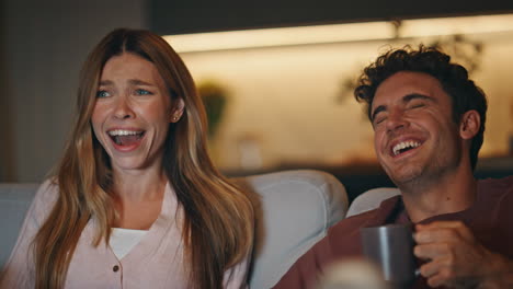 emotional pair watching television at night flat closeup. couple reacting film