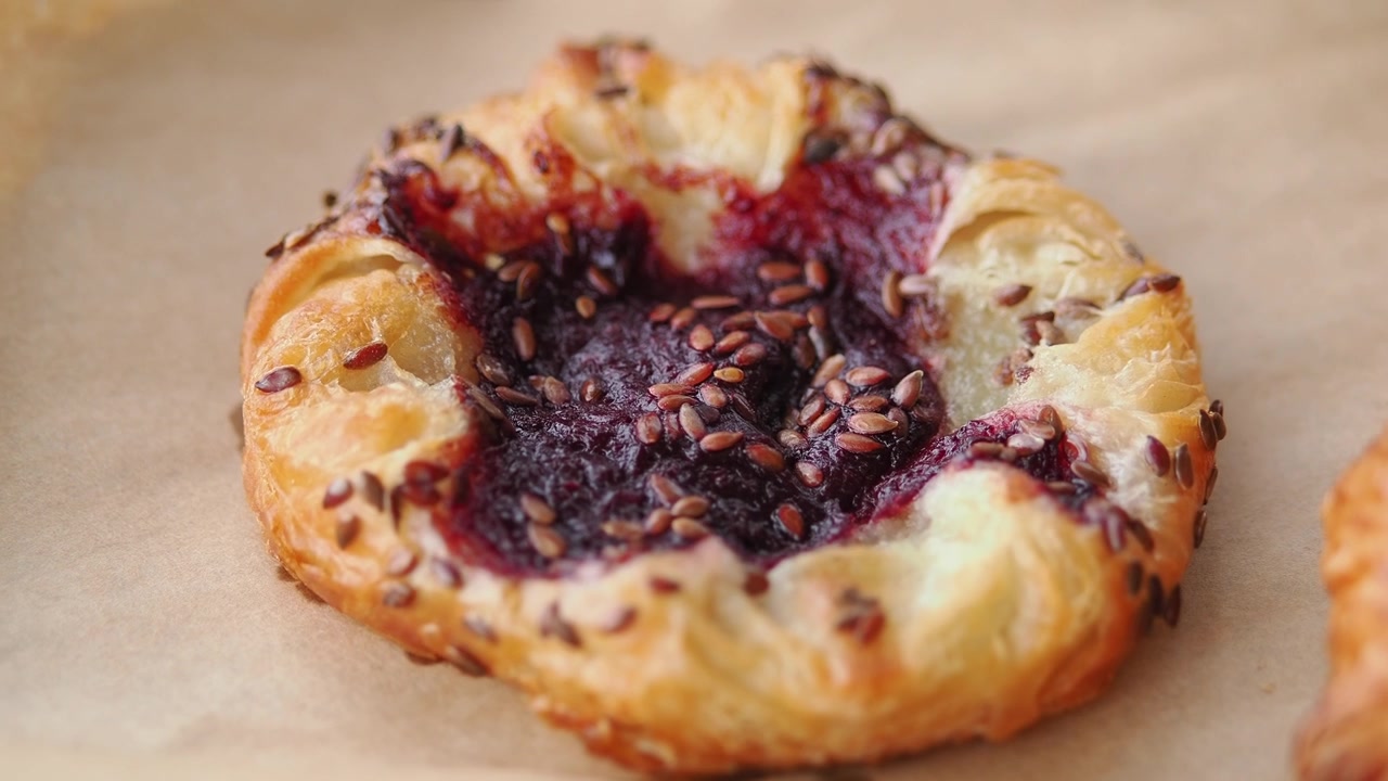 Primo piano di un pasticcino fresco ai frutti di bosco con semi e croissant