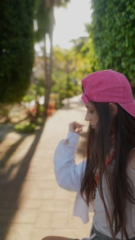 woman in pink baseball cap in park