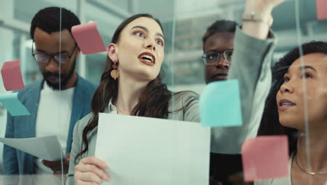 Glass,-wall-and-people-writing-sticky-note