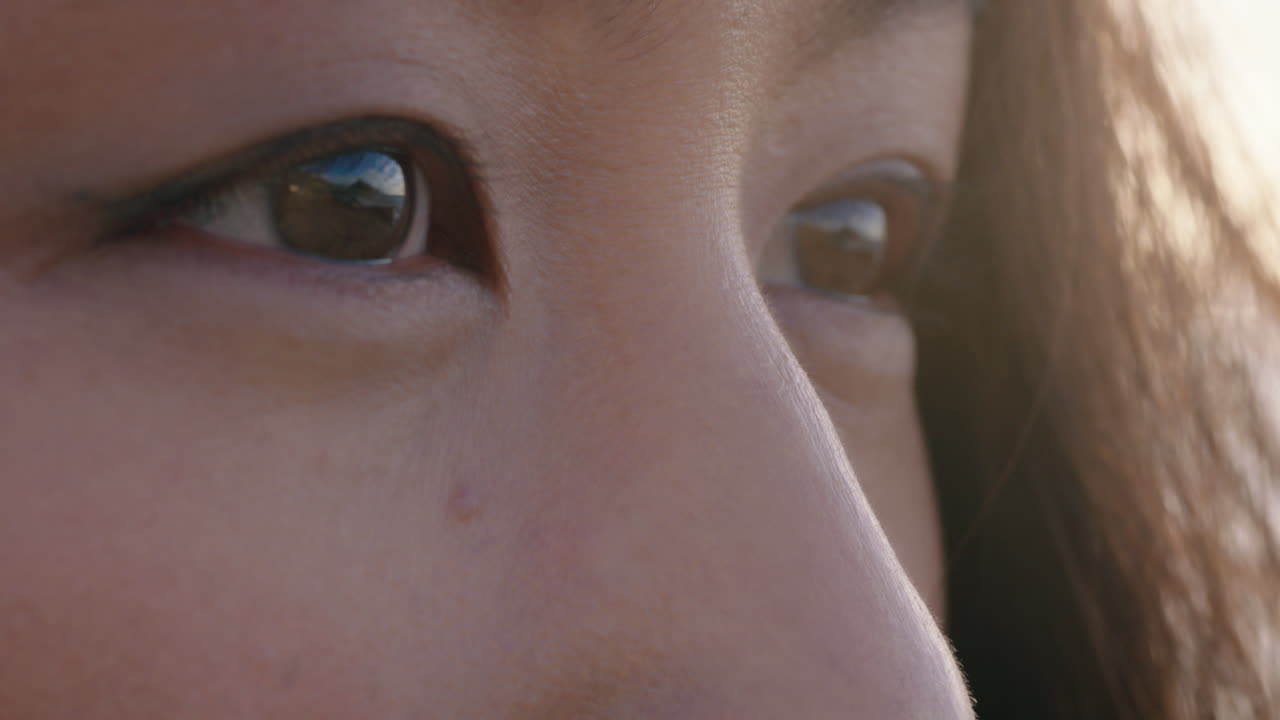 눈을 감고 아름다운 아시아 여성이 미래를 고민하고 마음 ⁇  즐기며 해가 지는 평화로운 해변에서 휴식을 취하고 있습니다.