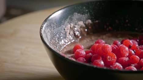 a close up shot panning across to reveal a dessert bowl filled with a low calorie pudding topped with sweet tasty frozen currants, a simple yet healthy sweet which is easy to make