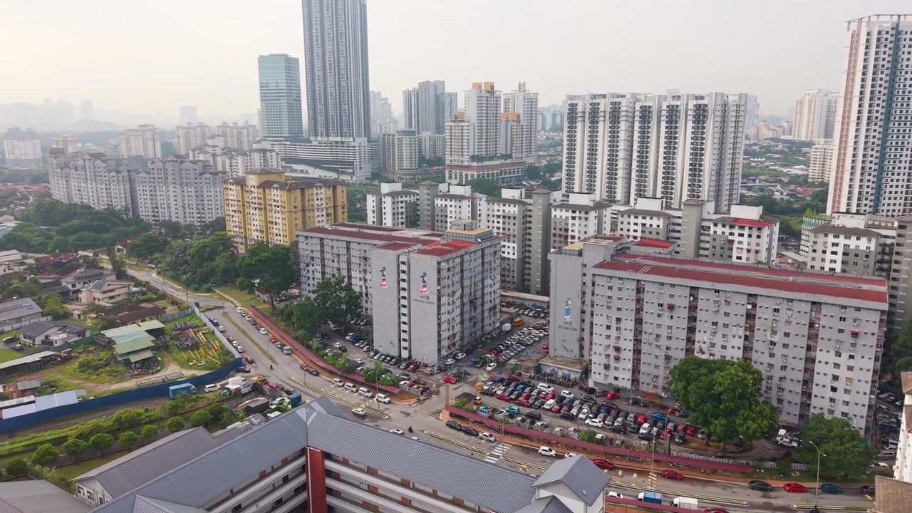 Tomada de drone com aproximação de Petaling Jaya, Malásia, mostrando um horizonte nebuloso, bairros residenciais e arranha-céus, ideal para conteúdo de desenvolvimento urbano e viagens, UHD