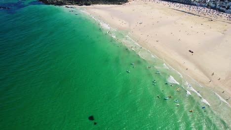 Drone-Aéreo-Disparado-Sobre-St-Ives-En-Cornwall-Con-Gente-Nadando-En-La-Playa-De-Porthmeor