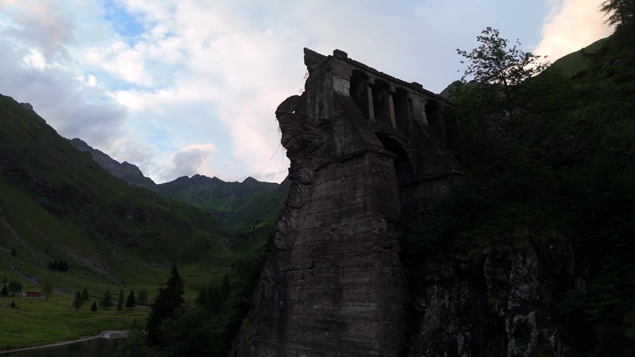 Luftfoto av ruinene etter den historiske Gleno-katastrofedammen ved solnedgang i Val di Scalve, Lombardia, de italienske Alpene, Italia.