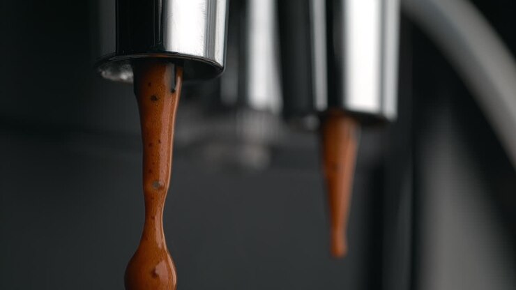 Droplets Of Coffee Dripping From Espresso Machine’s Double Portafilter Spout in Macro and Slow Motion