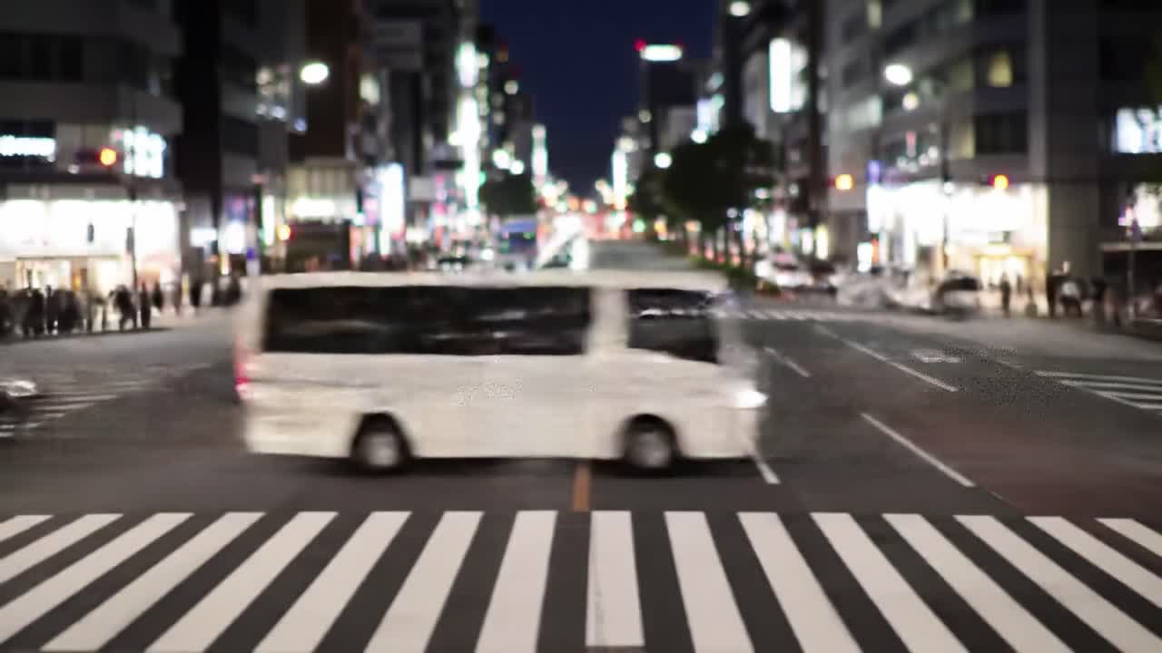Nighttime Urban Crossing with Motion: A Yellow Bus and Vehicles Navigate a Busy Intersection Captured in a Blurred Scene of City Life
