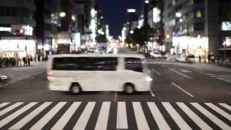 nighttime urban crossing with motion: a yellow bus and vehicles navigate a busy intersection captured in a blurred scene of city life