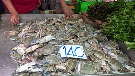 person selling fresh crabs at a market