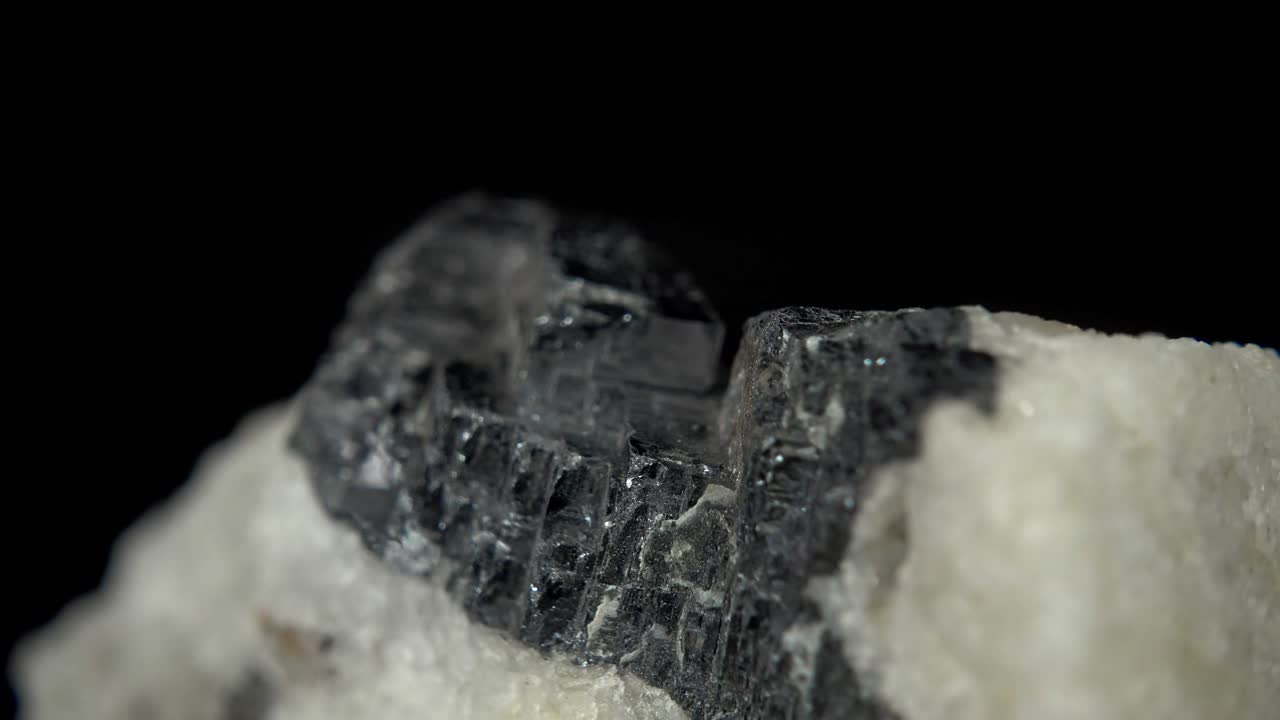 검은 바탕 앞에 금속 미네랄 (갈레나) 을 원활하게 회전시키는 것